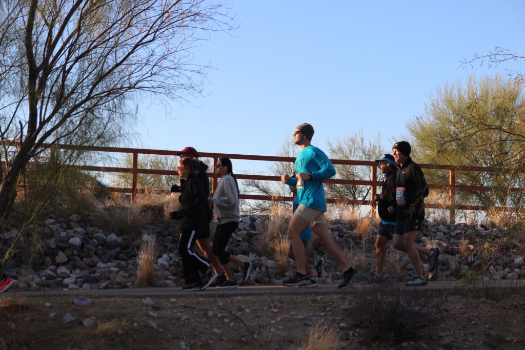 Adults running along outdoor trail
