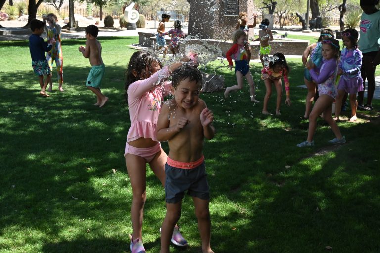 kid splashing a water balloon over another kid's head