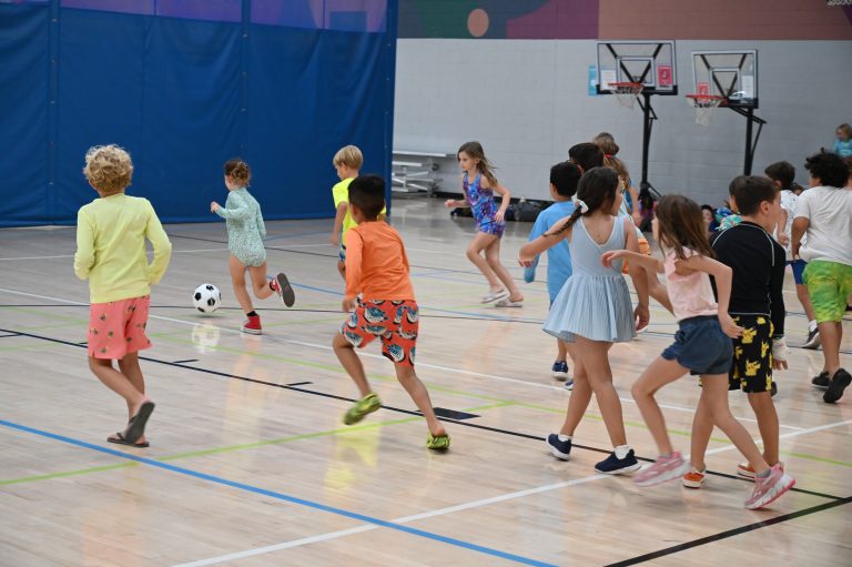 kids playing soccer in a gymnasium