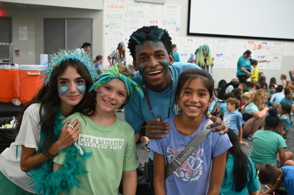two kids and two counselors smiling to the camera