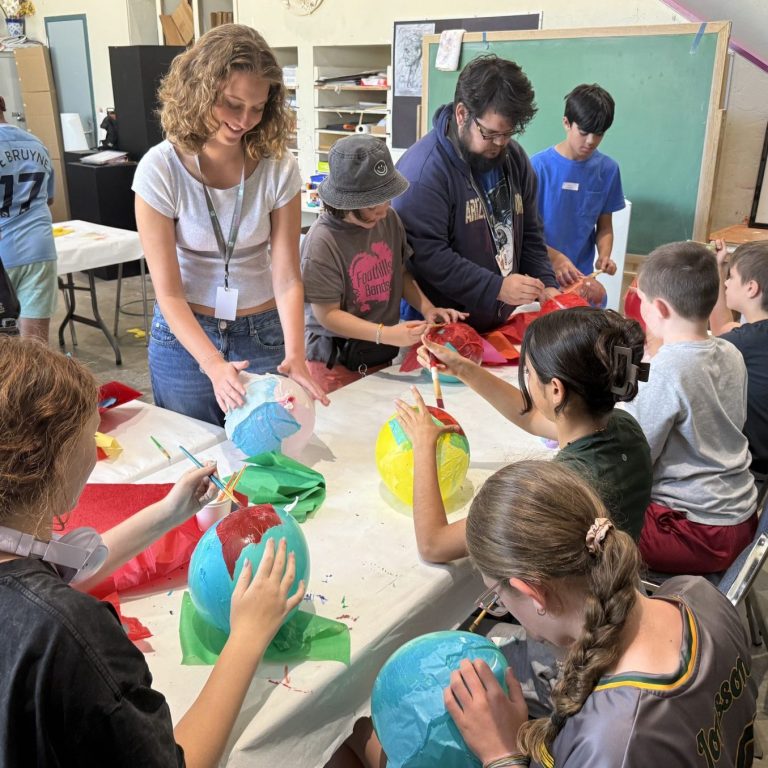 teenagers using paper mache on balloons