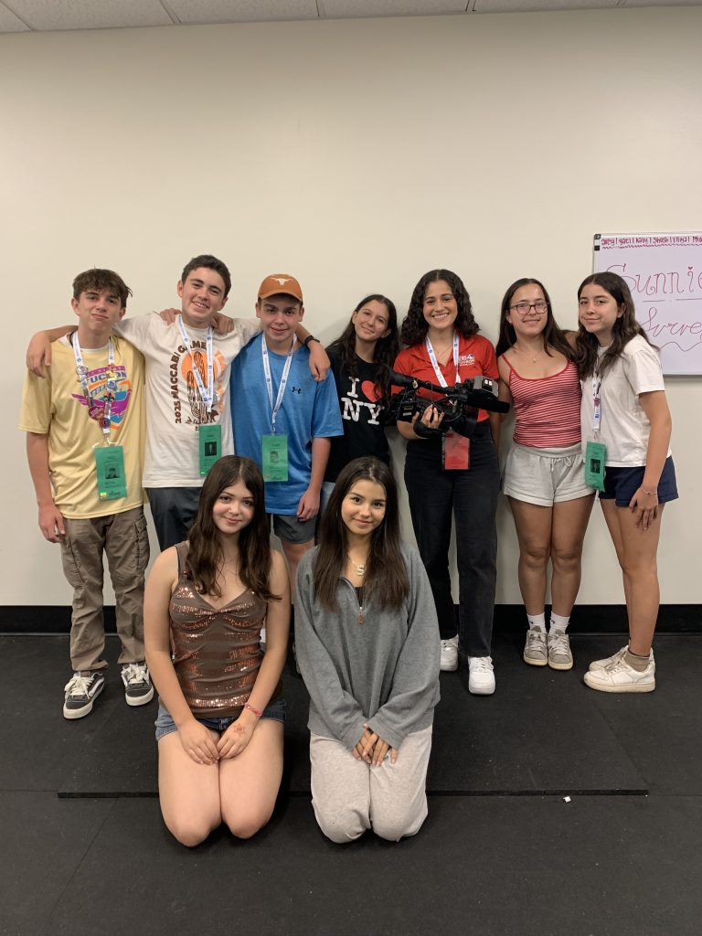 a group of nine teens standing and smiling together