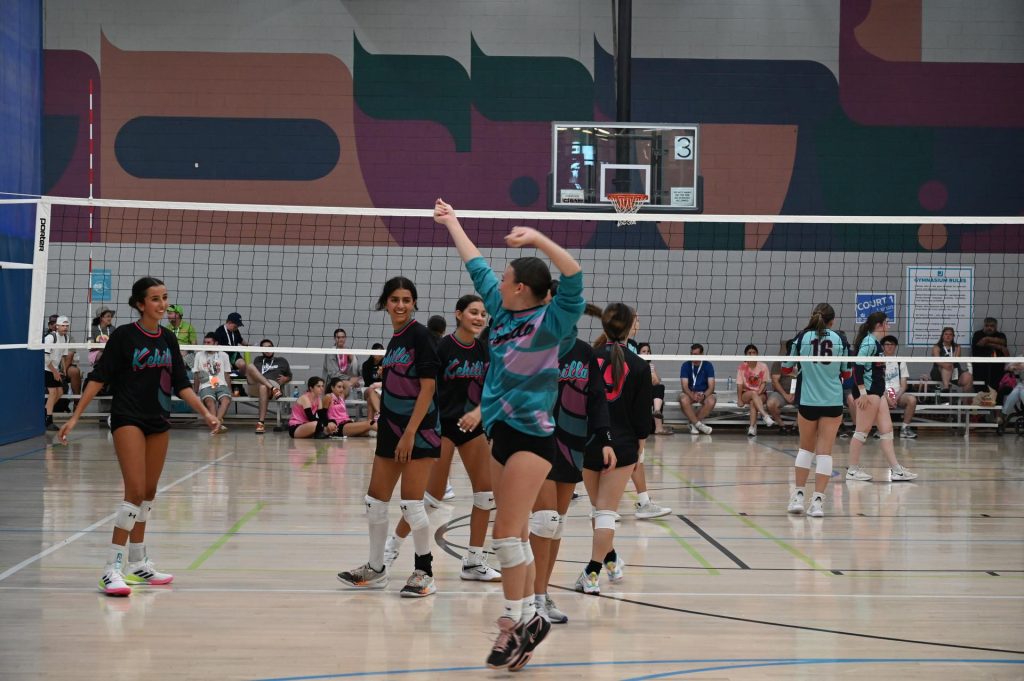 JCC Maccabi girls volleyball athletes smiling on the volleyball courts
