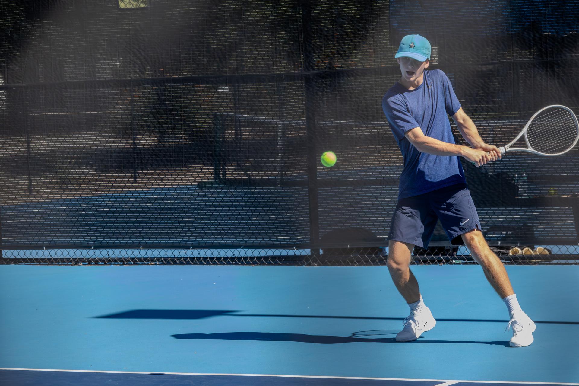 JCC Maccabi teen hitting a tennis ball outside on tennis courts