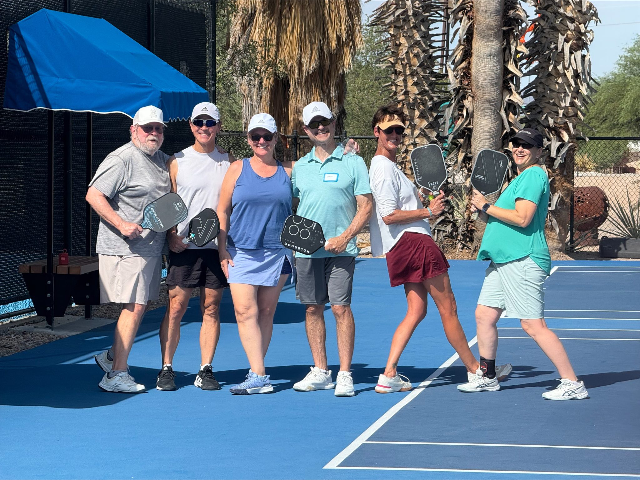 a group of people posing with their pickleball paddles