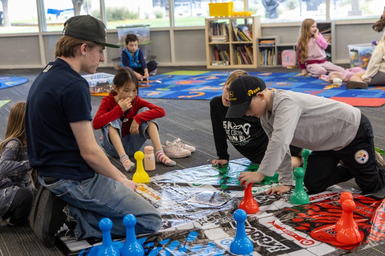 Three kids and one adult play a board game